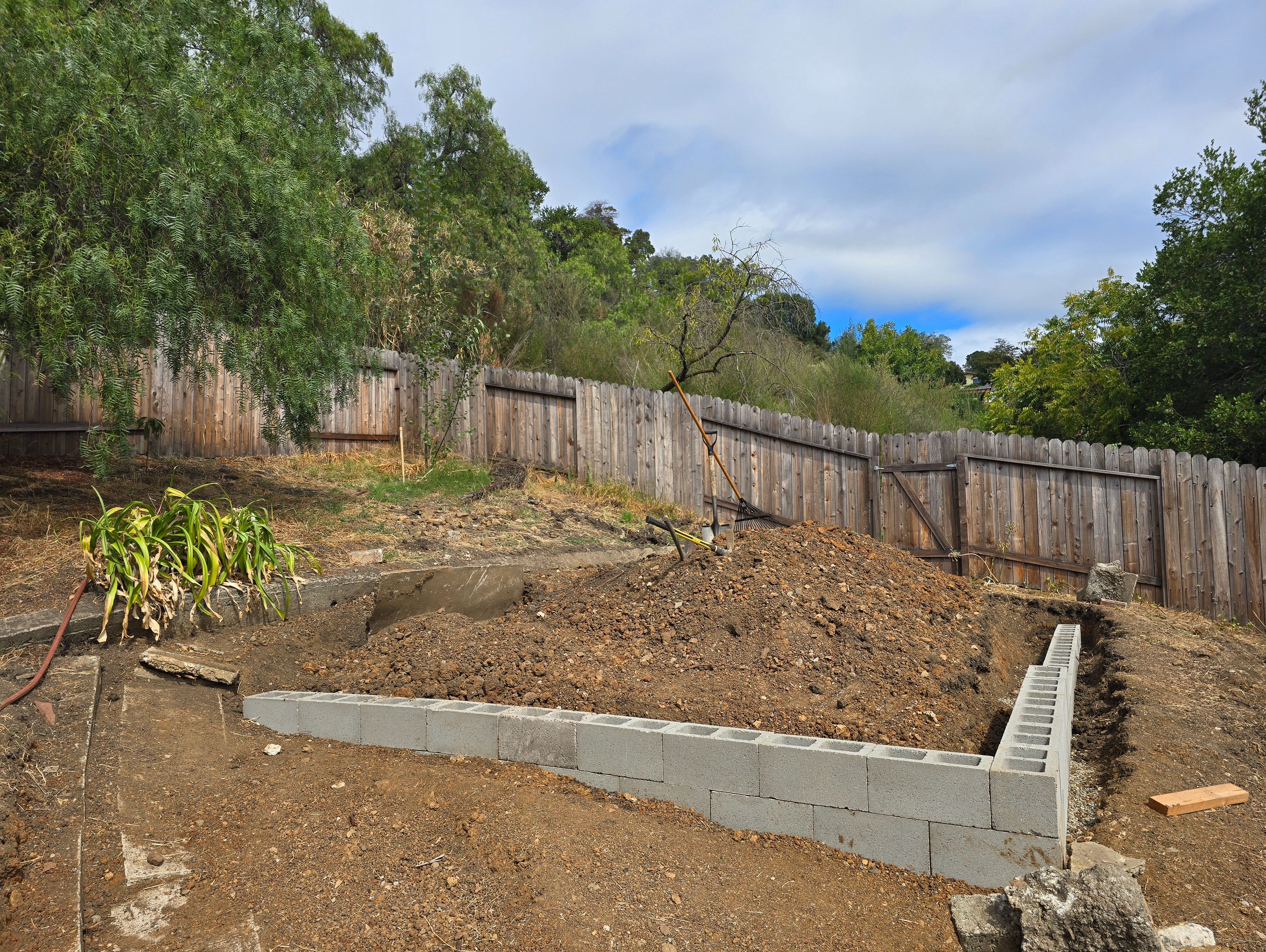 Using pick and sledge hammer to level below the wall